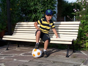 Gartenbank mit jungem Fussballspieler